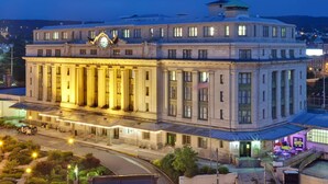 Un grand bâtiment historique, doté d’un imposant clocher et d’une façade bien éclairée.