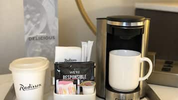 Una bandeja con una cafetera, una taza blanca, un dispensador de servilletas y sobres de crema.