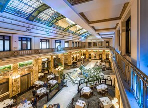 A spacious hotel lobby with a central courtyard, multiple dining areas, and a grand staircase. - Radisson Lackawanna Station Hotel Scranton (Scranton)