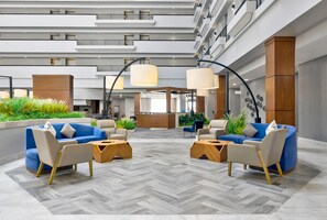 Un hall amplio con muebles modernos, suelo de espiga y una mesa de recepción.