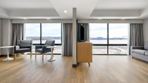 A modern hotel room with a large window, a flat-screen TV, and a wooden desk. - DoubleTree by Hilton Davenport (Davenport)