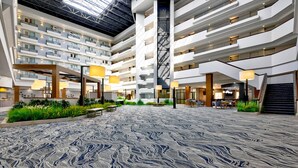 A multi-level hotel atrium with a central open space, multiple balconies, and indoor plants. - DoubleTree by Hilton Davenport (Davenport)