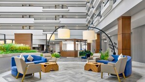 A spacious lobby with modern furniture, a herringbone floor, and a reception desk. - DoubleTree by Hilton Davenport (Davenport)