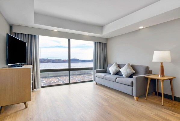 Suite, 1 cama King size | Área de sala de estar | Televisión y películas con cargo 