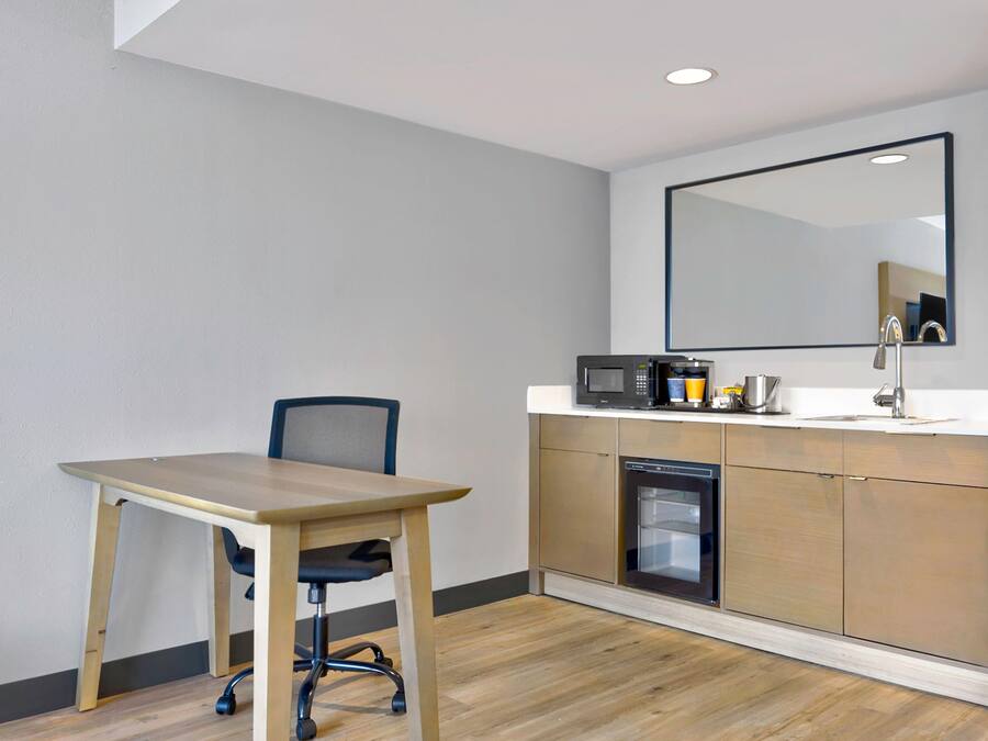 A small kitchenette with a microwave, coffee maker, and sink.