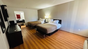 A hotel room with two beds, a desk, a mirror, and a bathroom visible through an open door. - Super 7 Inn Tupelo (Tupelo)