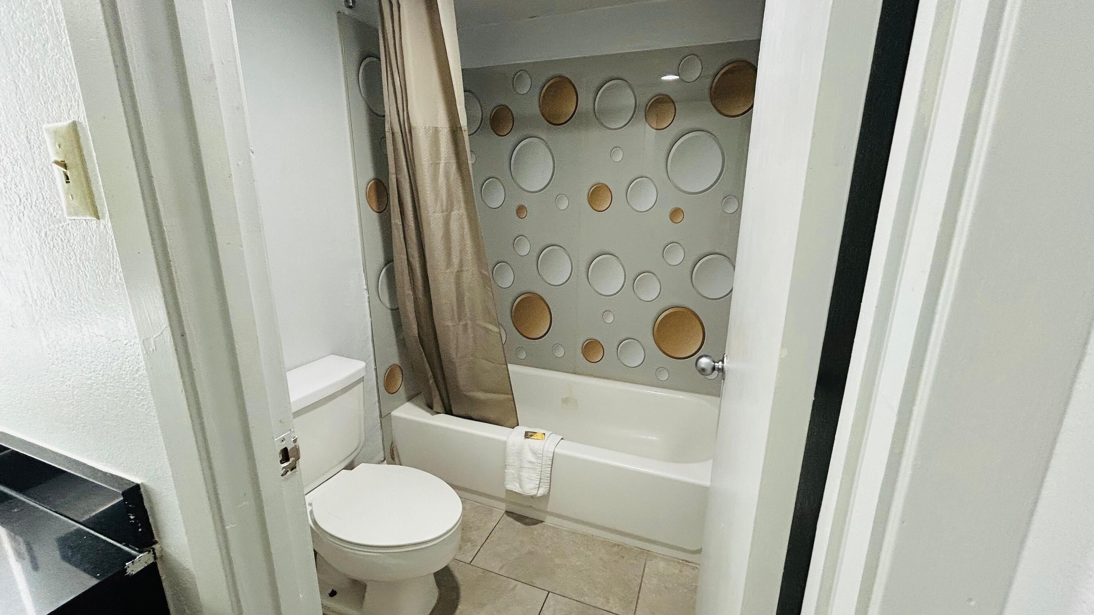 Un baño pequeño con inodoro, bañera y cortina de ducha.