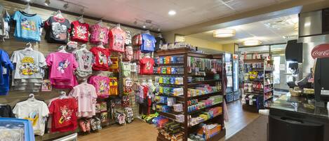 A retail store with shelves stocked with various products and a display of colorful merchandise.