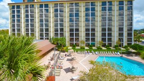 A hotel with a pool, sun loungers, and a well-maintained garden.