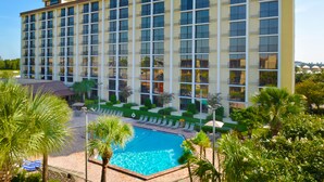 A large hotel building with a swimming pool in front. - Rosen Inn, closest to Universal (Orlando)