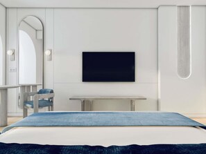 A modern bedroom with a bed, a TV mounted on the wall, a desk, and a chair.
