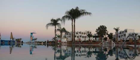 Una piscina al aire libre, sombrillas