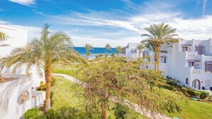 A coastal resort with white buildings, palm trees, and a view of the sea. - Mercure Hurghada Hotel (Hurghada)