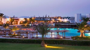 A resort with a swimming pool, outdoor seating, and a building with arches. - Mercure Hurghada Hotel (Hurghada)