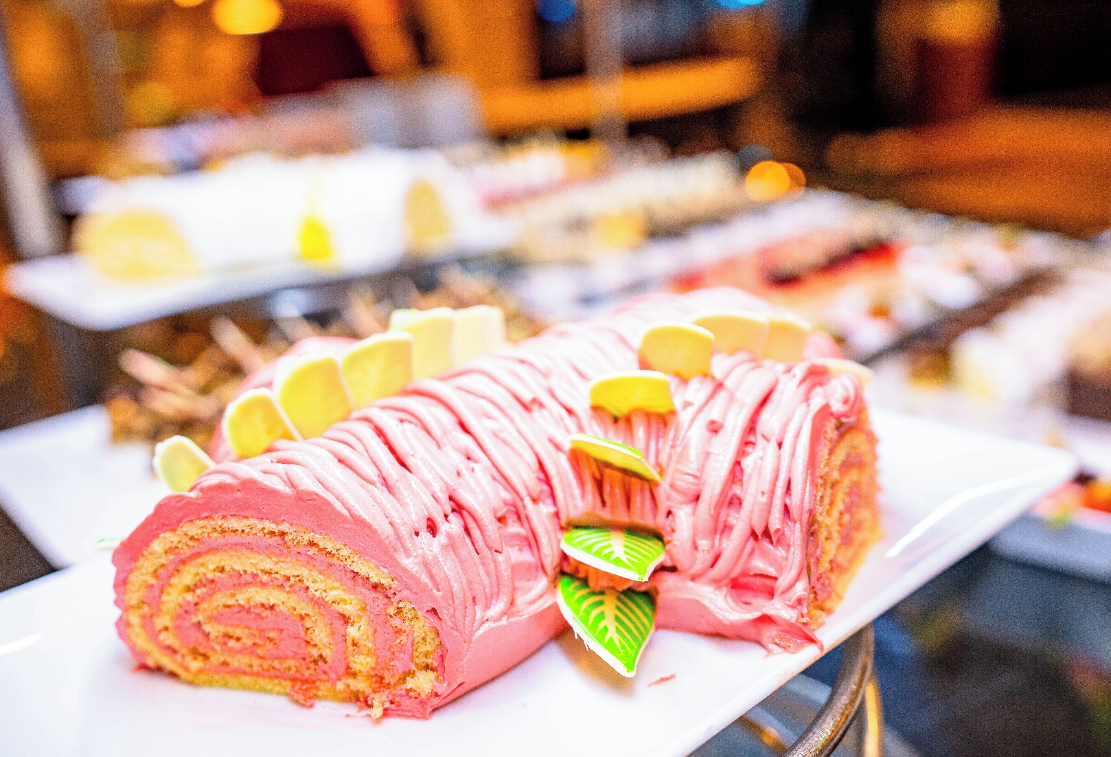 Une présentation de desserts comprenant un gâteau roulé rose et des tranches de citron.