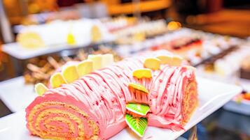 Une présentation de desserts comprenant un gâteau roulé rose et des tranches de citron.