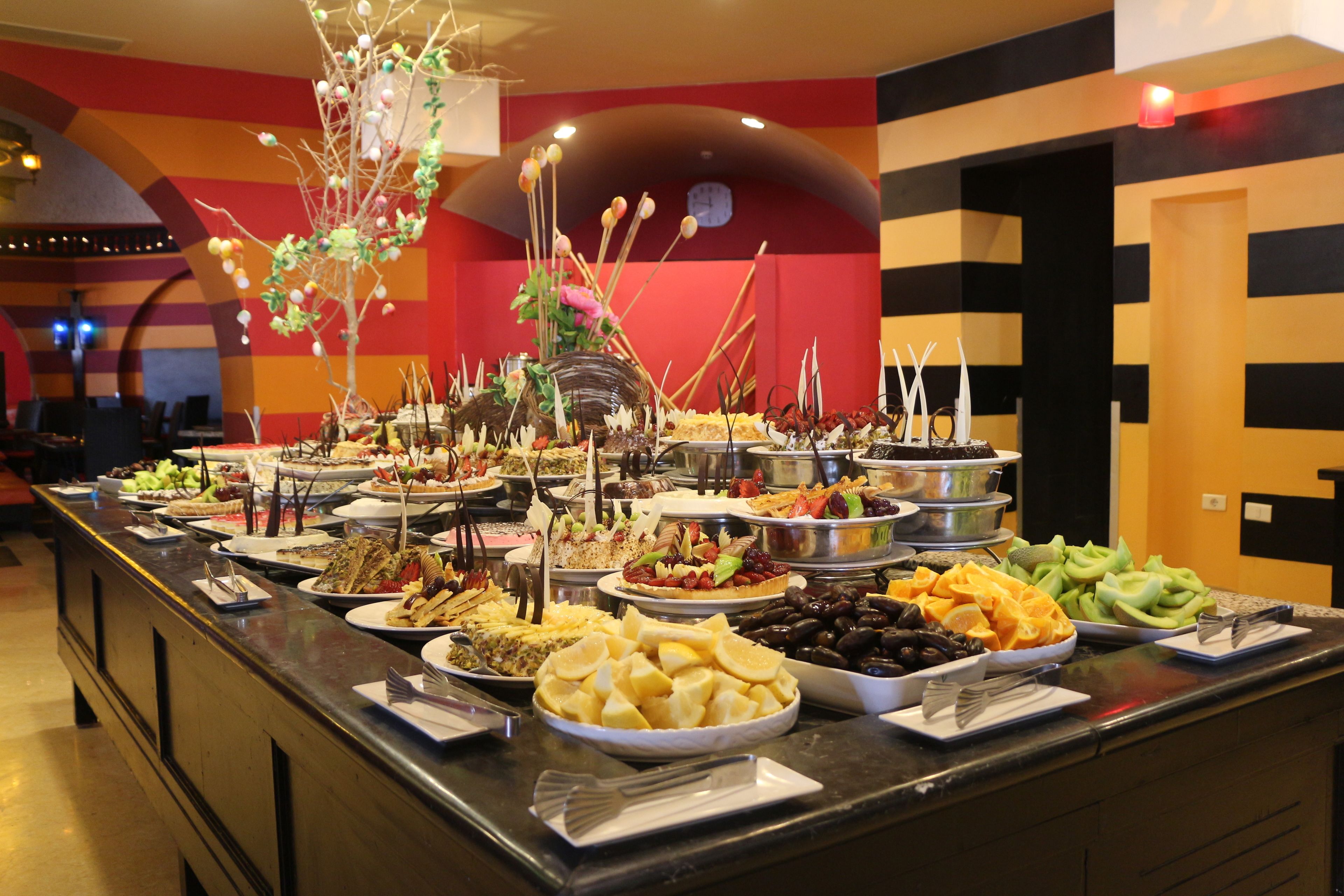Un bufé con diversos alimentos y un árbol decorativo como centro de mesa.