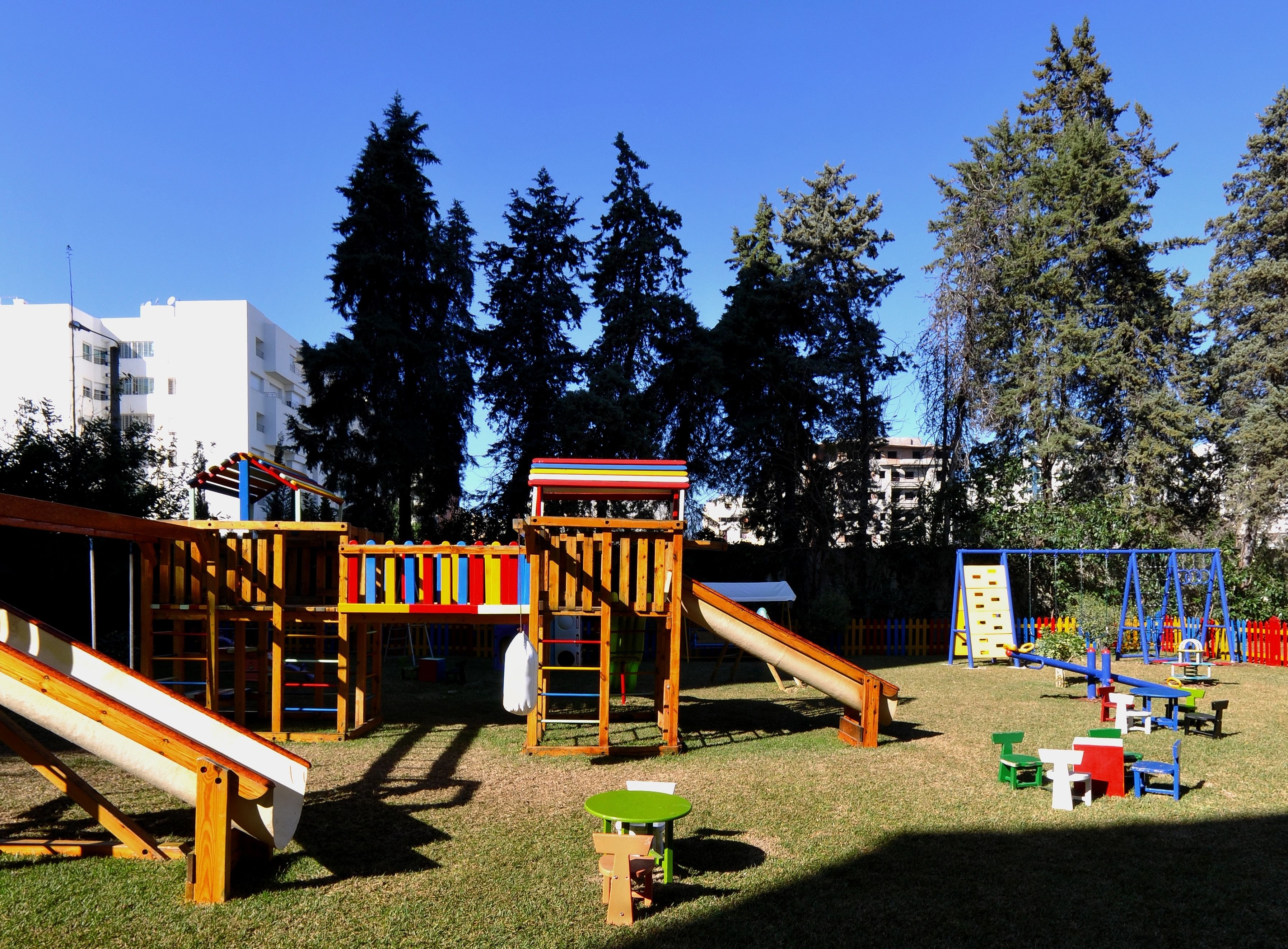 Un parque infantil con toboganes, estructuras para escalar y una pequeña mesa.