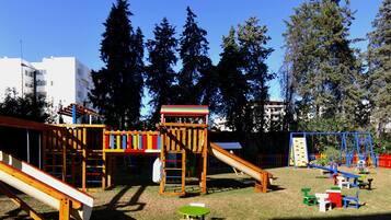 Un parque infantil con toboganes, estructuras para escalar y una pequeña mesa.
