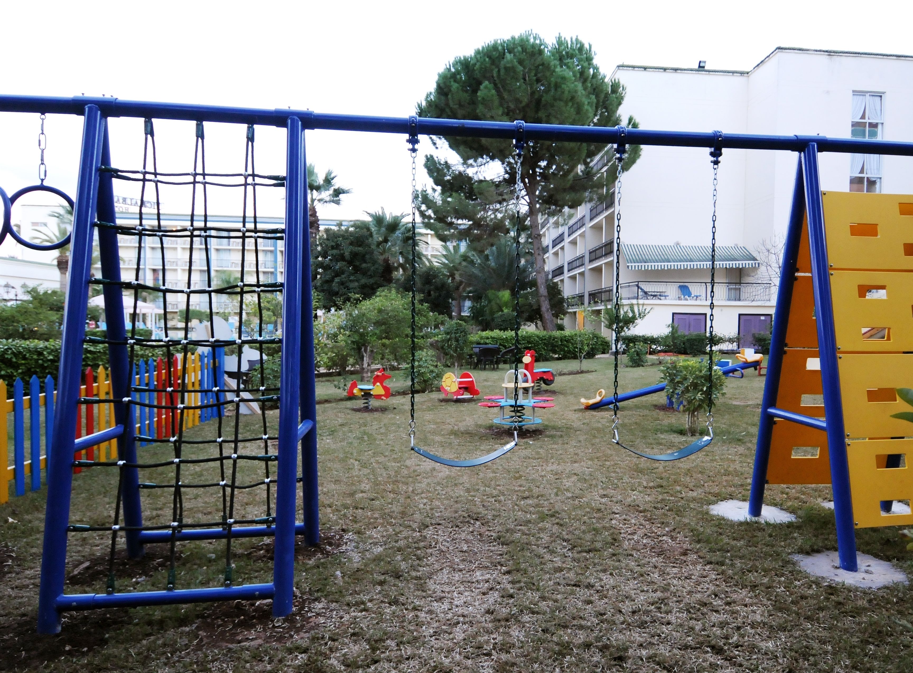 A playground with various play structures including swings, slides, and climbing frames.