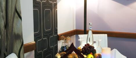 Un tavolo da pranzo con diversi cibi, una bottiglia e una lampada.