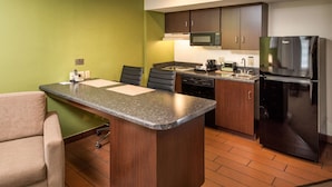A compact kitchen with a central island, a microwave, a refrigerator, and a dishwasher. - Sleep Inn Charleston North (Charleston)