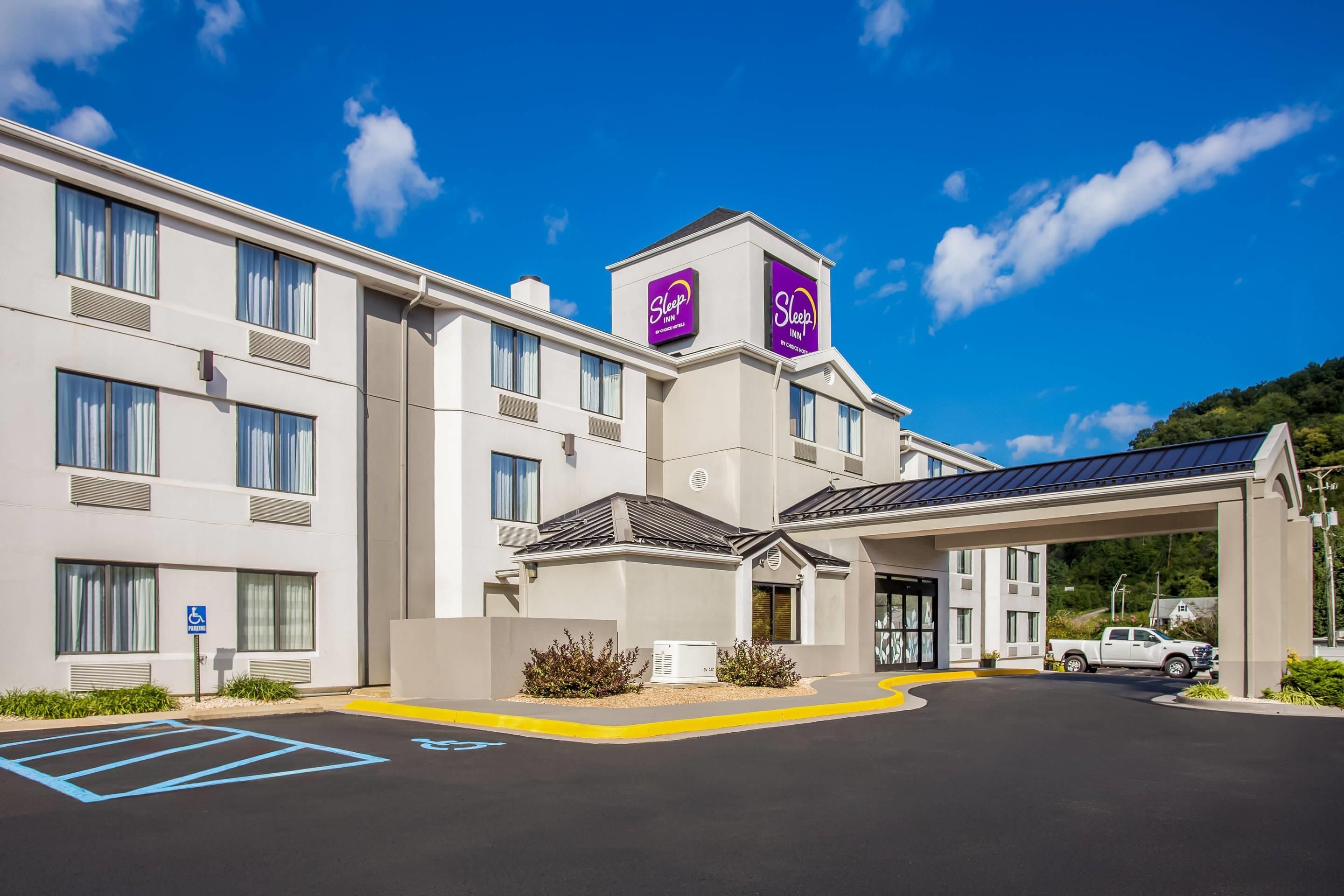 A Sleep Inn hotel with a modern design, a covered entrance, and a parking area with handicapped spaces.