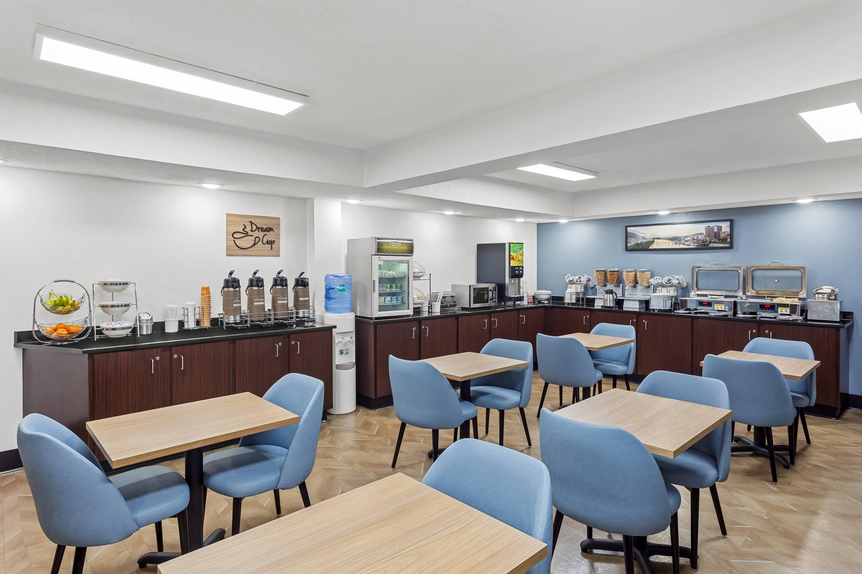 A modern cafe with multiple seating areas, a coffee station, and a refrigerator.