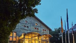 A stone building with a glass entrance and flags.