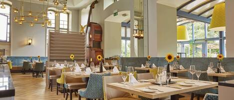 Un restaurant doté de plusieurs tables, de chaises et d’un escalier.