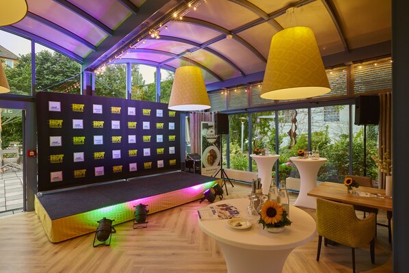 Un interior moderno con un escenario, zona de estar y comedor.