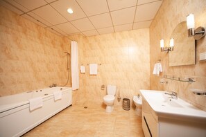A modern bathroom with a bathtub, toilet, and sink. - Black Sea Central (Odessa)