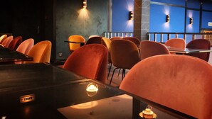 A restaurant with a modern interior, featuring red upholstered chairs and tables, and blue accent walls. - Hotel Hannong (Strasbourg)