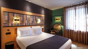 Une chambre d’hôtel avec un grand lit, un bureau et une chaise.