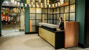 A reception desk with a modern design, featuring a counter and a seating area. - Hotel Hannong (Strasbourg)