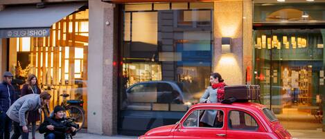 Ein roter Oldtimer parkt vor einem Gebäude mit einer Schilder für Hannong Hotel & Wine Bar.