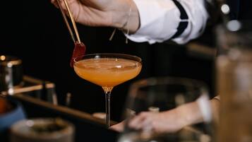 A bartender holding a cocktail shaker with a martini glass.
