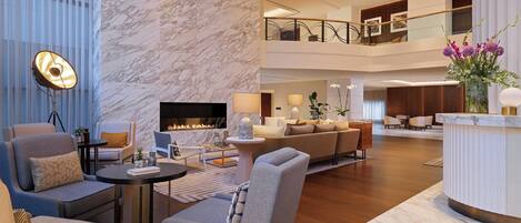 A spacious lobby with a fireplace, comfortable seating, and a modern design.