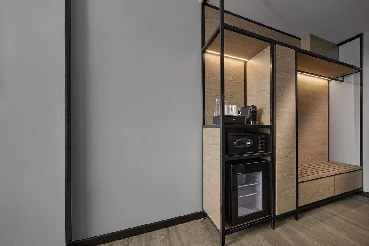 Een moderne, compacte kitchenette met geïntegreerde apparatuur, een koffieapparaat en een minibar.