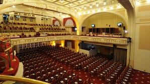 Un teatro con varios niveles de asientos, un techo ornamentado y un escenario.