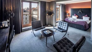 A modern hotel room with a large bed, two armchairs, a small table, and a floor lamp. - Scandic Front (Copenhagen)