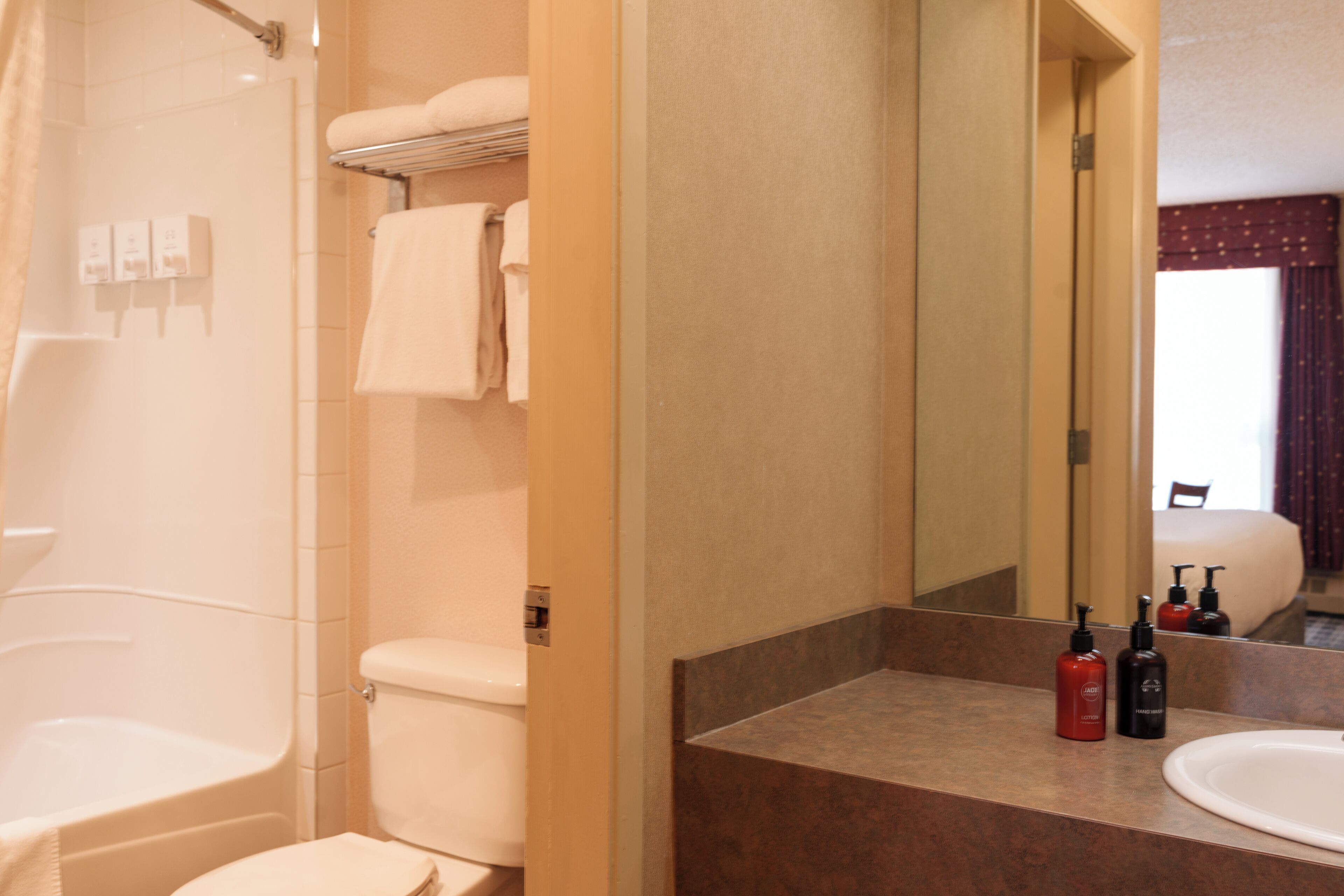 Une salle de bain équipée d’une baignoire, de toilettes et d’un lavabo avec des articles de toilette.
