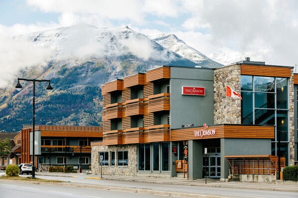 A hotel with a stone facade, wooden balconies, and a sign indicating vacancies. - The Crimson Jasper (Jasper)