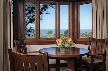 A modern bar area with a marble countertop, black cabinetry, and patterned floor tiles. at The Lodge at Torrey Pines