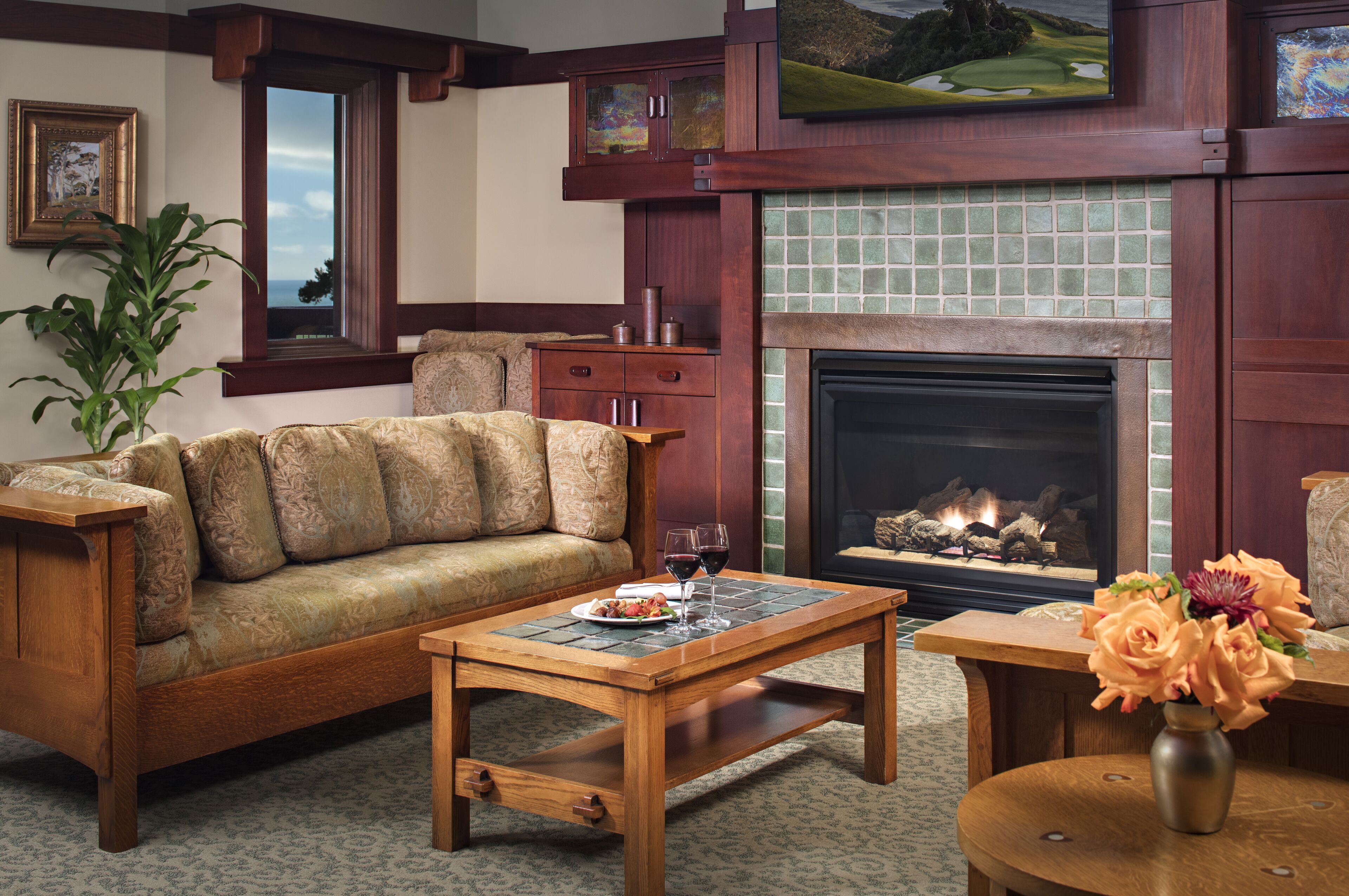 A cozy living room with a sofa, coffee table, fireplace, and a painting on the wall.