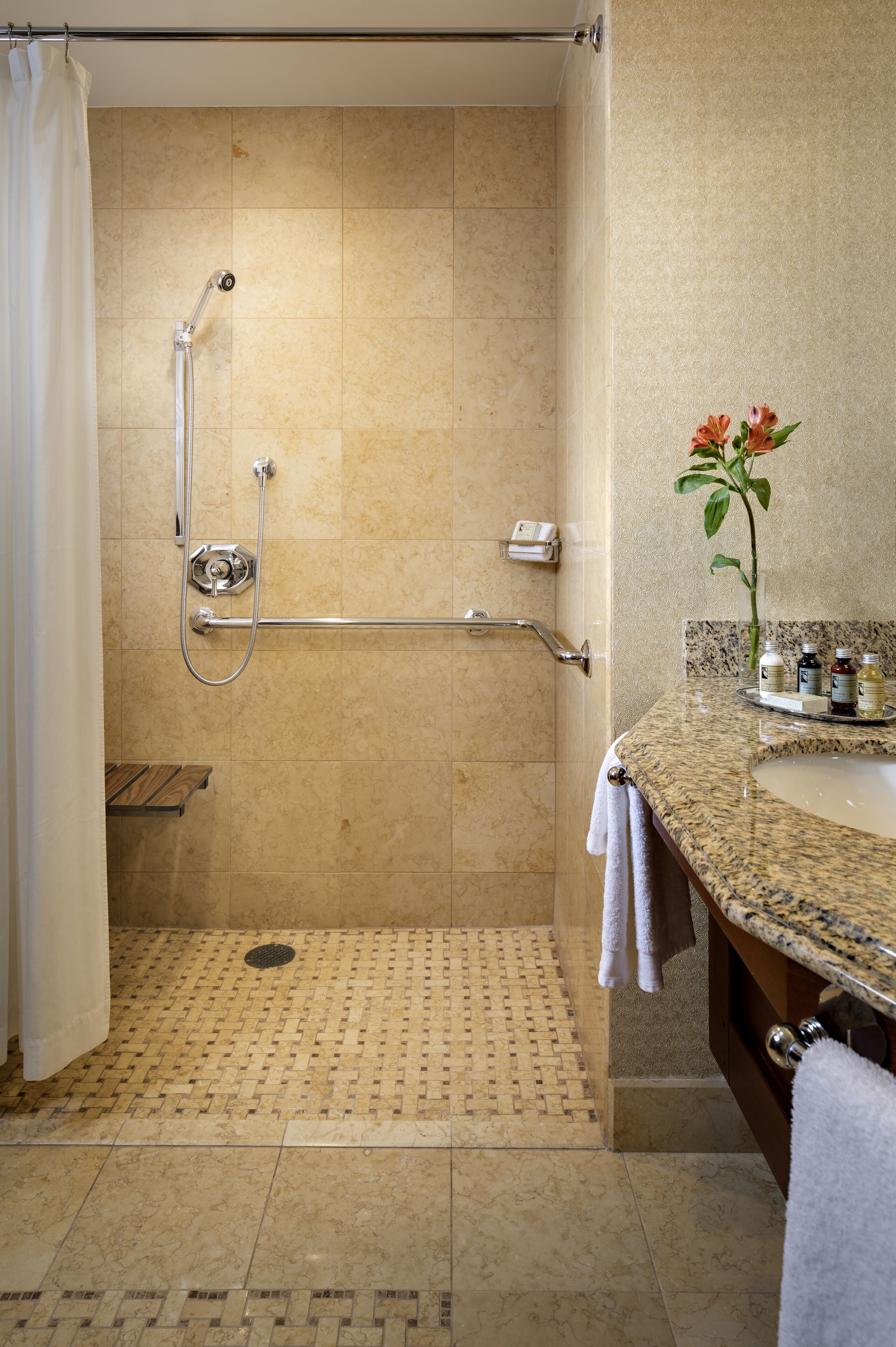 A bathroom with a shower, a sink, and a vanity.
