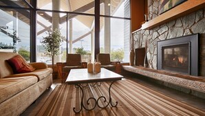 Una sala de estar acogedora con chimenea, ventanas amplias y asientos cómodos.