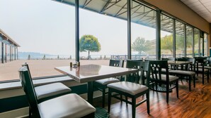 Un restaurante con terraza, amplios ventanales y vistas al frente marítimo.