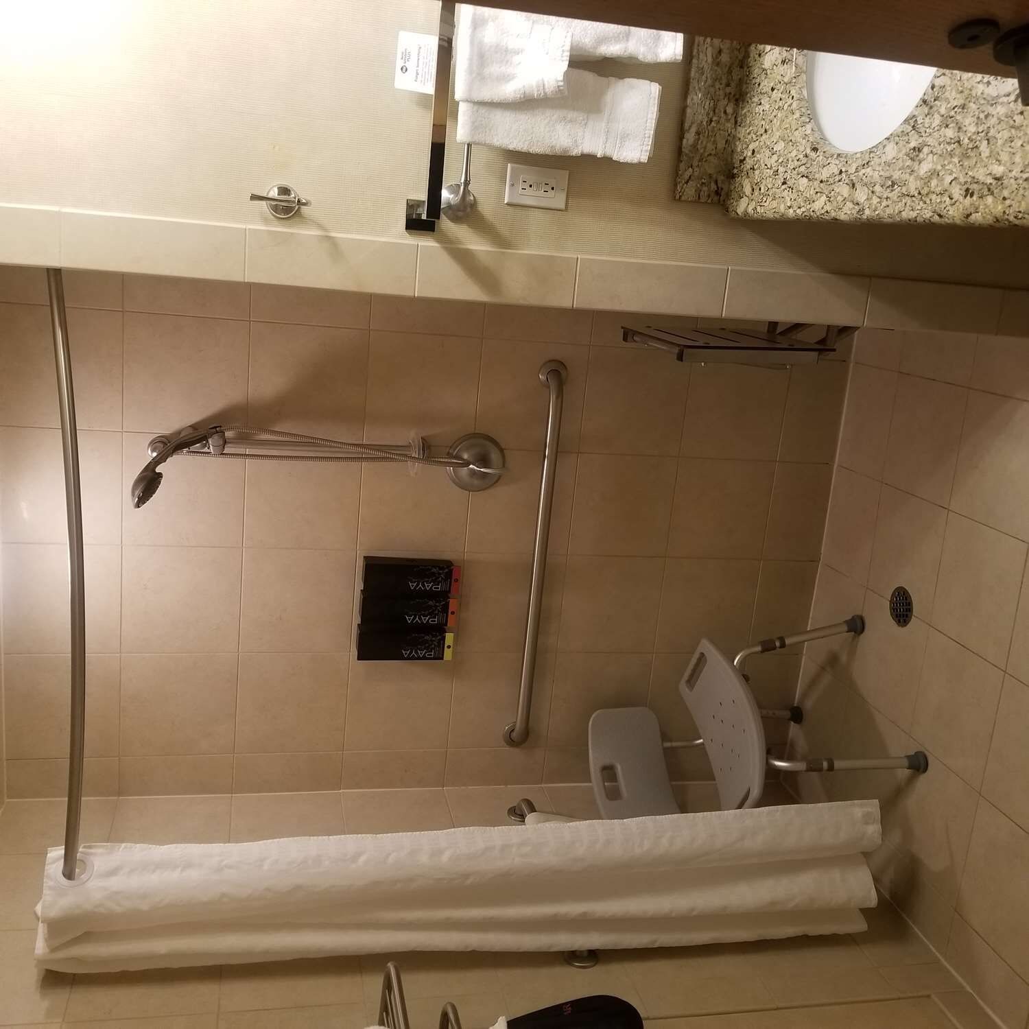 Une salle de bain équipée d’une douche, de toilettes et de barres d’appui.