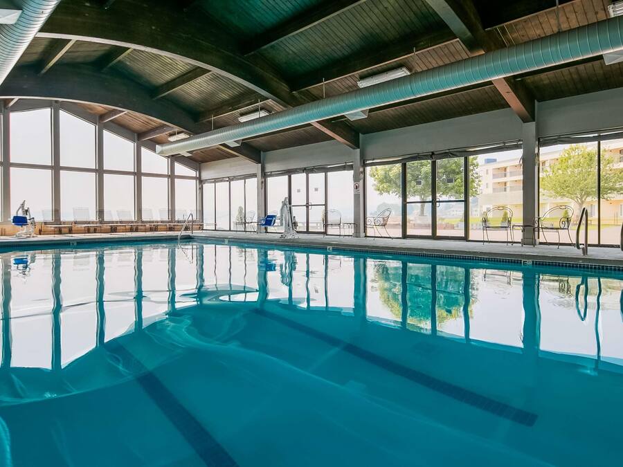 Una piscina interior con agua cristalina, ventanas amplias y vistas al exterior.